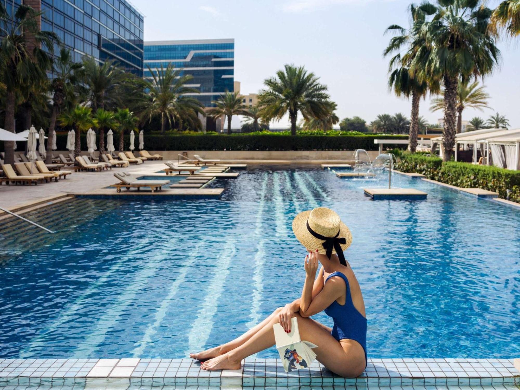 ホテル フェアモント バーブ アル バハール アブダビ エクステリア 写真 A woman sunbathing at a pool